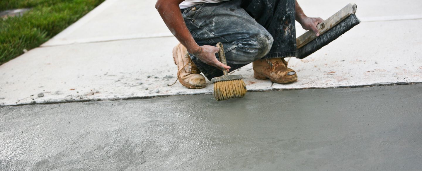 construction worker finishing up concrete work on driveway orange tx